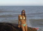 Hot babe in bikini stands on a rock