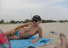 Fancy girlie sits topless for a hot tan