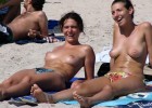 Hot topless chicks sharing a joke at the beach