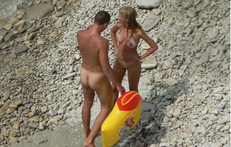 Nudist couple exposed on a rocky beach