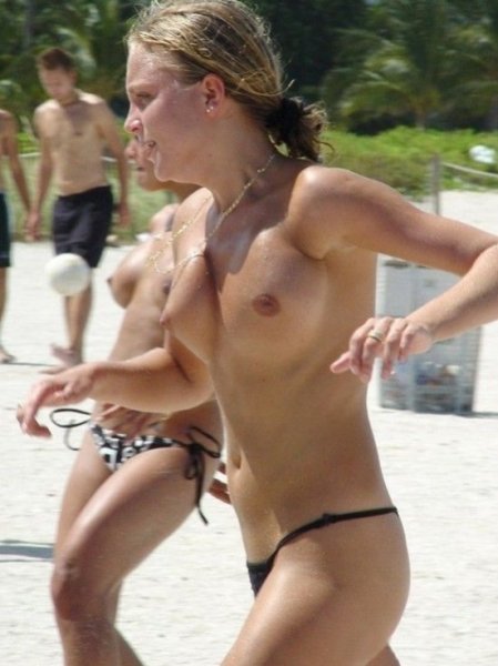 Sexy topless friends jogging along the shore