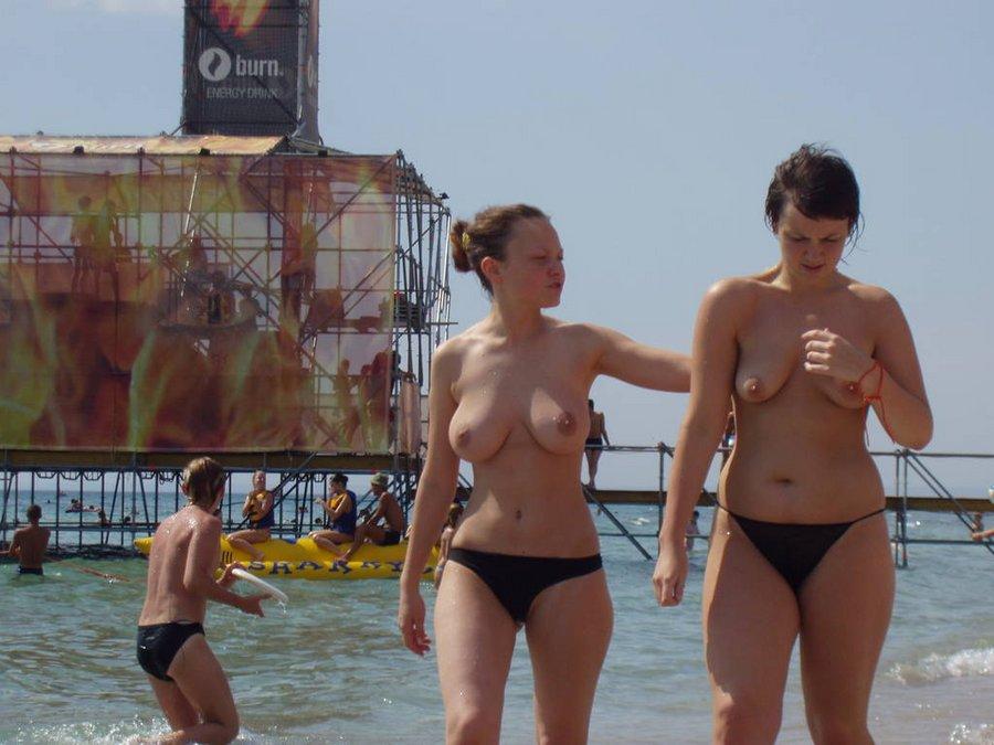 Two hot teens walking on the beach topless