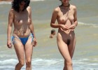 They are walking on the shore exposing titties